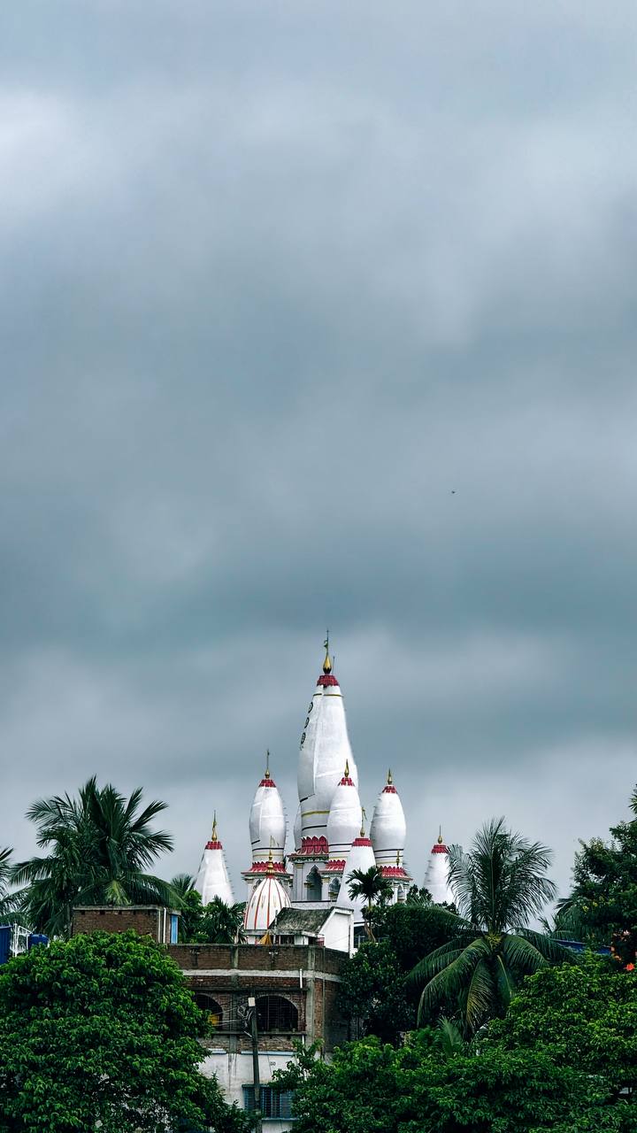 White temple spires rising above palm trees