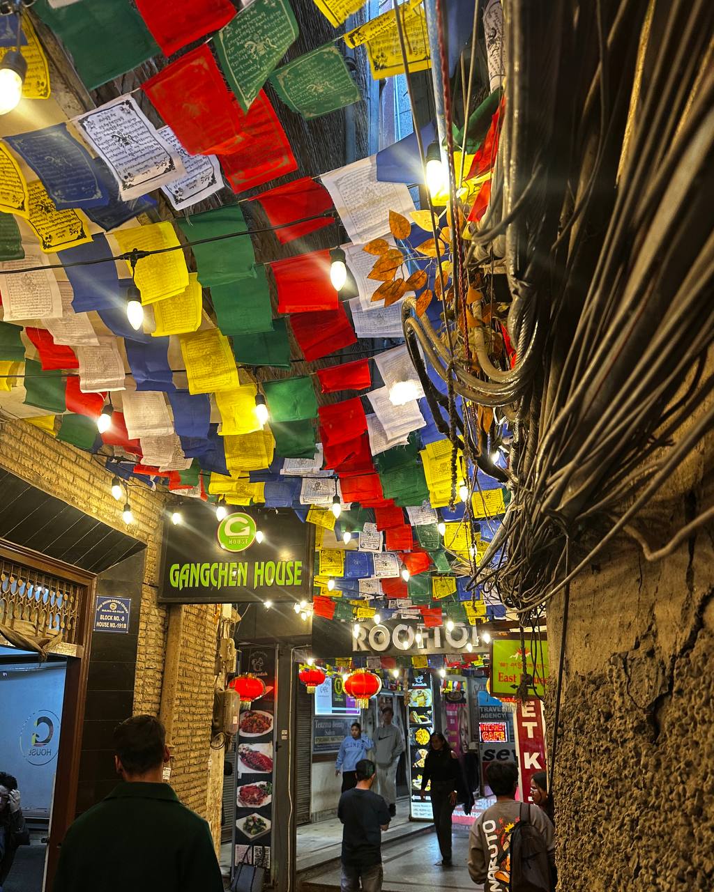 Colorful prayer flags strung across narrow lanes of Majnu Ka Tilla