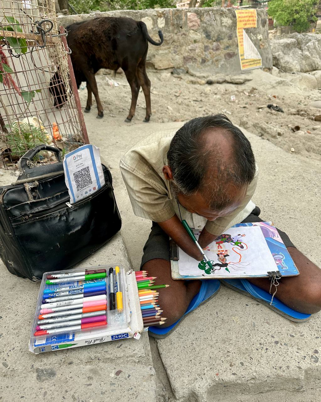 Street artist painting with his feet next to a QR code for digital payments