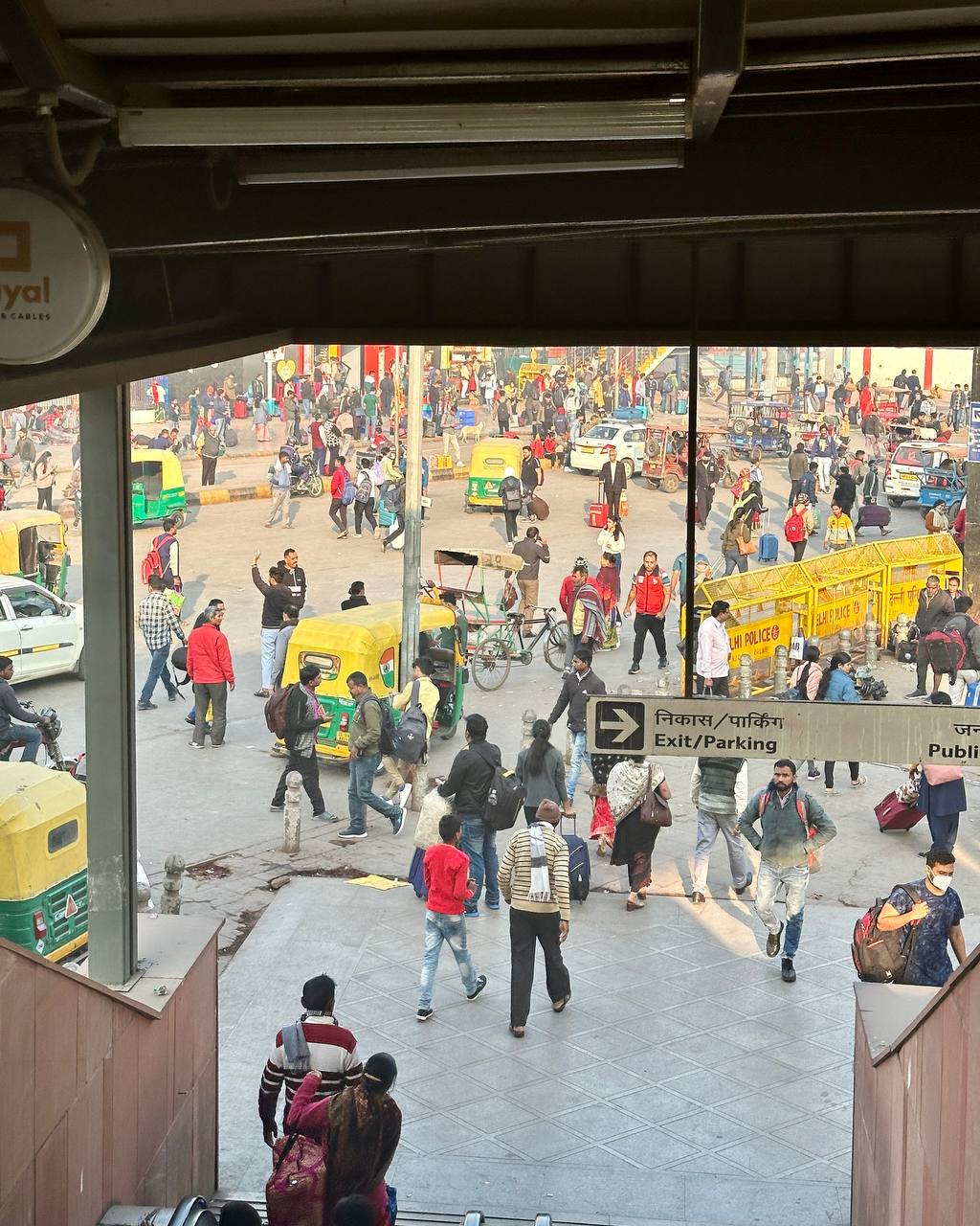 New Delhi Railway Station entrance with crowds and auto-rickshaws